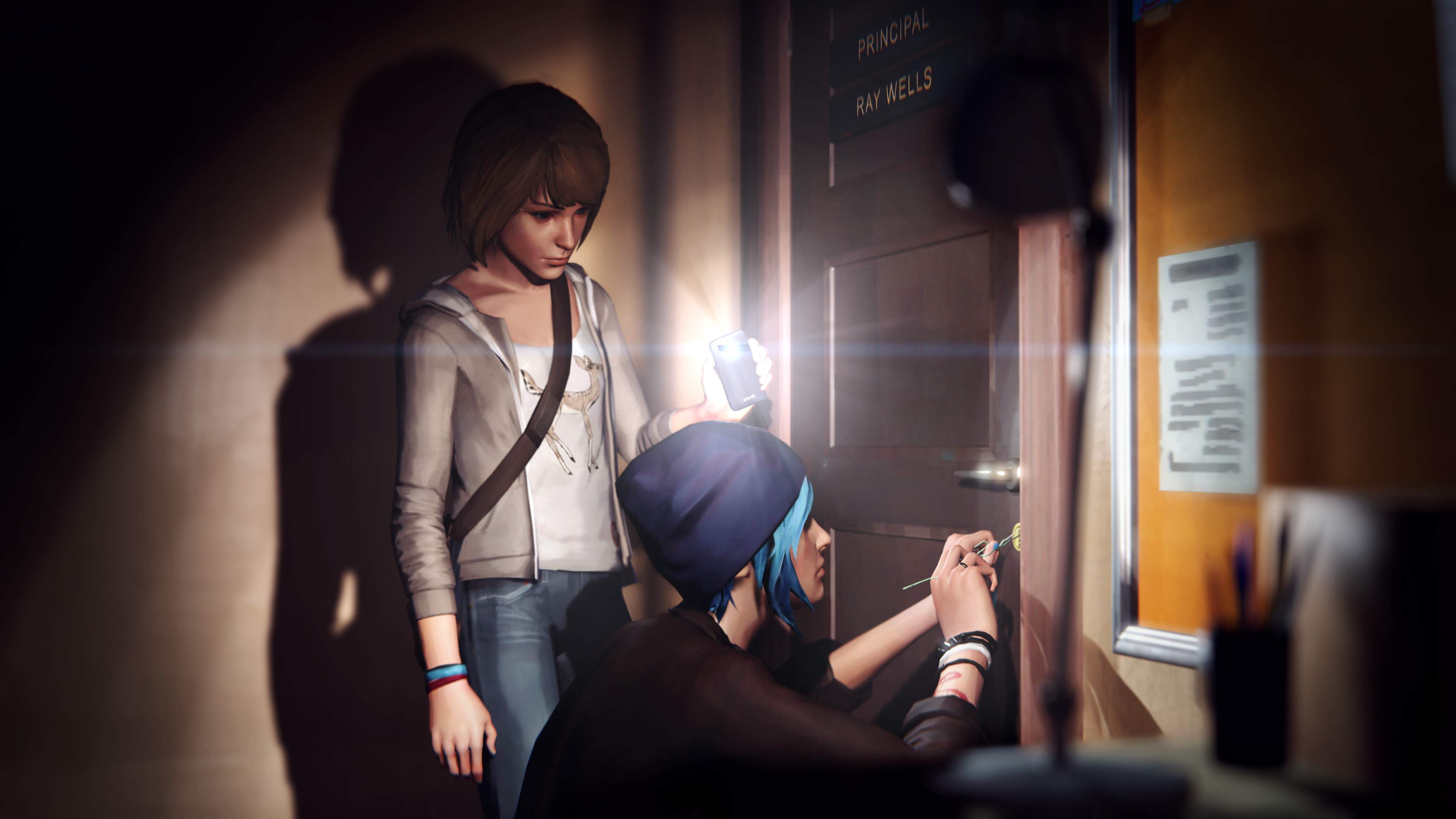 In a dark Blackwell Academy corridor at night, Max's shines her phone flashlight as Chloe picks a lock.