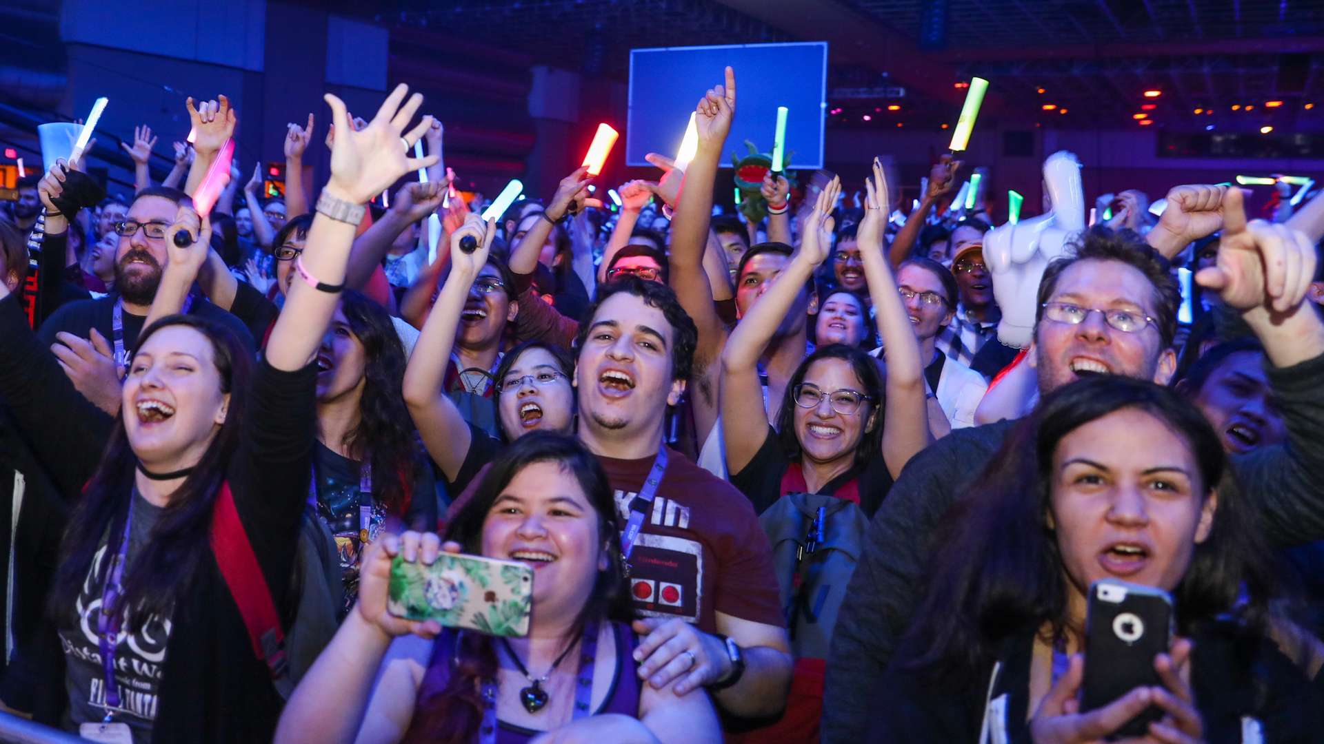 Photo of event attendees cheer and raising their hands in celebration.