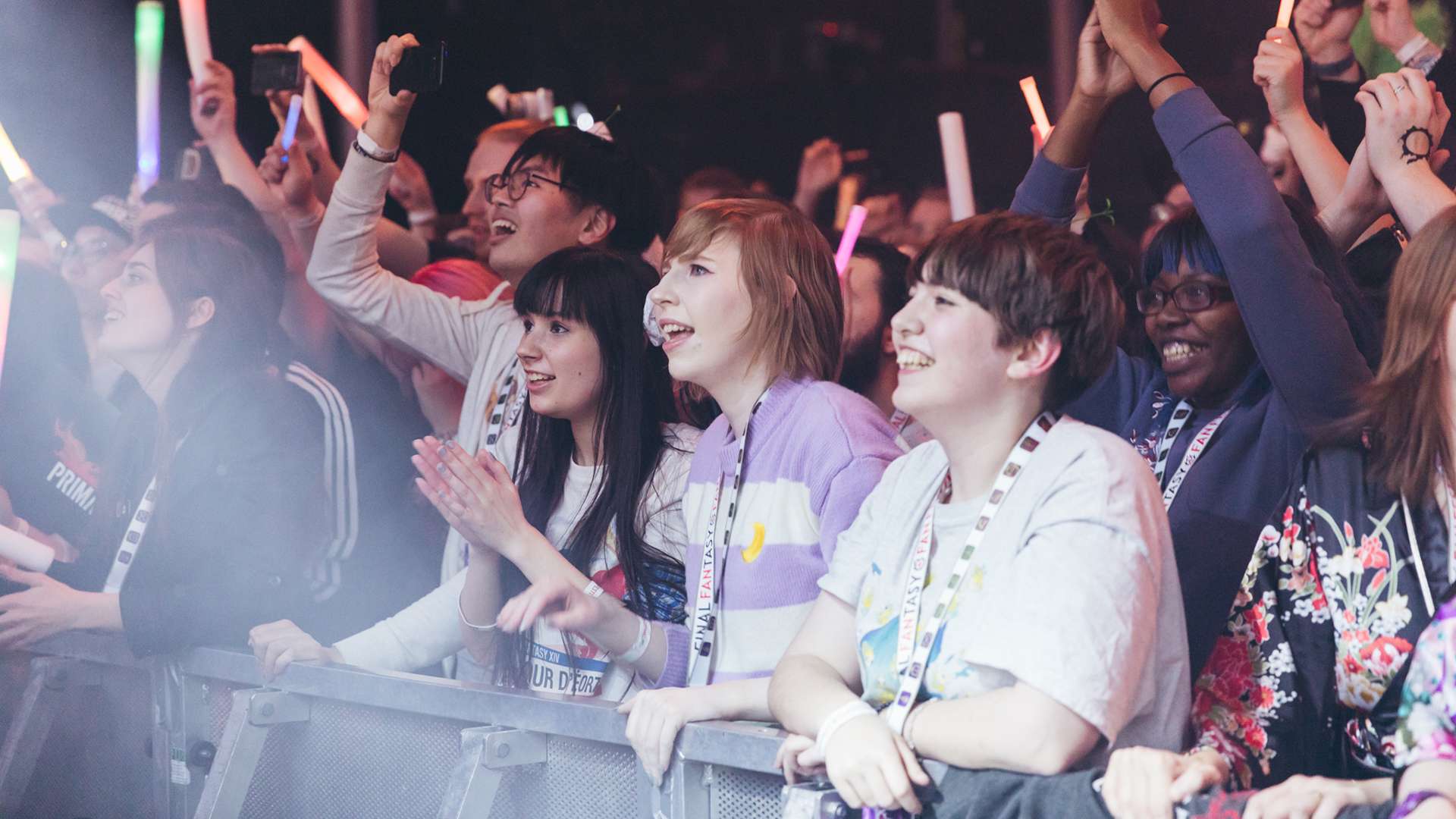 Photo of event attendees cheering and raising their hands in celebration.