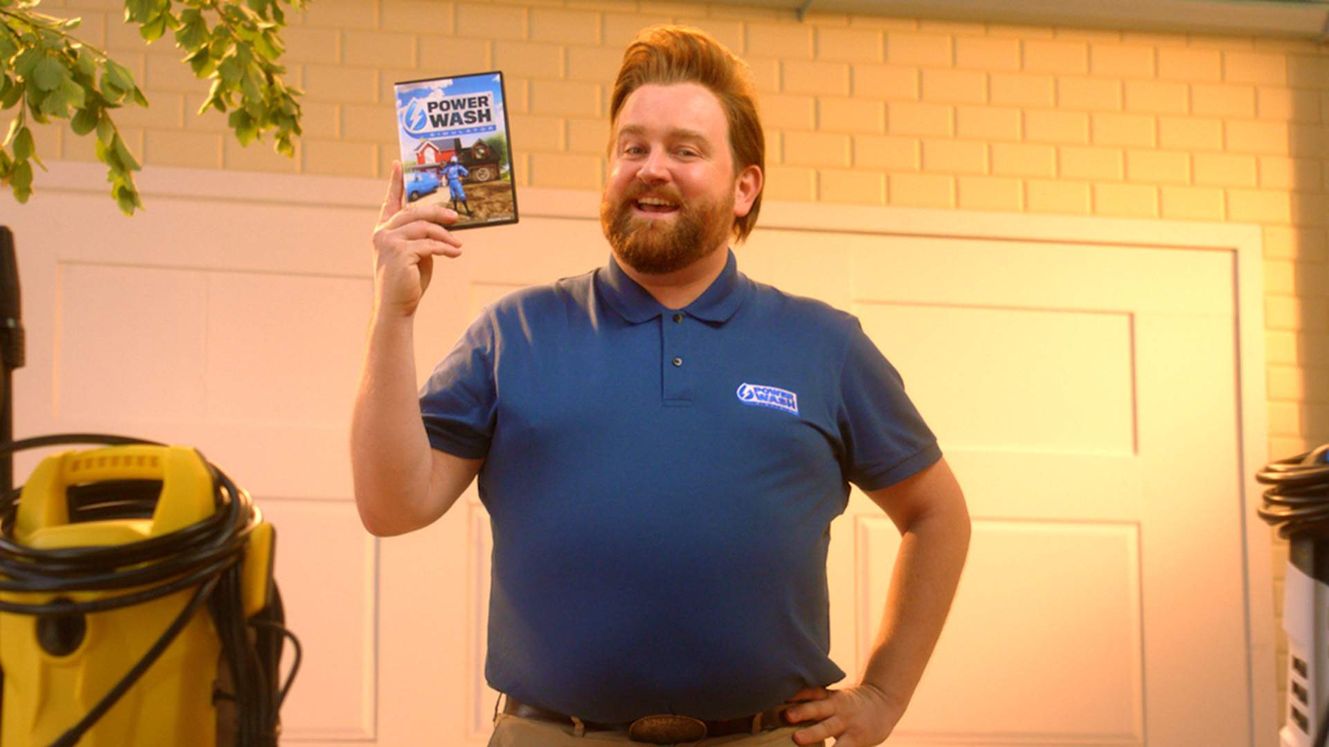 Kenny Washmore steht neben einem Hochdruckreiniger vor einer Garage und präsentiert Powerwash.